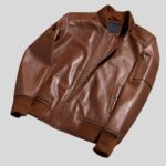 Flach gelegte cognacfarbene Bomberjacke aus Leder für Herren mit Reißverschluss und Strickbündchen