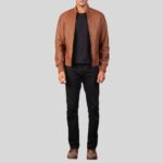 Frontalansicht eines Mannes in cognacfarbener Leder-Bomberjacke, schwarzem Shirt, schwarzer Jeans und braunen Stiefeln