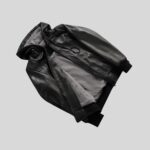 Innenansicht schwarze Kapuzenlederjacke für Herren – flachgelegt mit grauem Innenfutter