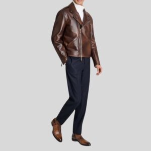 Modell trägt braune Glattlederjacke im Bikerstil mit Reißverschluss, kombiniert mit weißem Rollkragenpullover, dunkelblauer Hose und braunen Schuhen