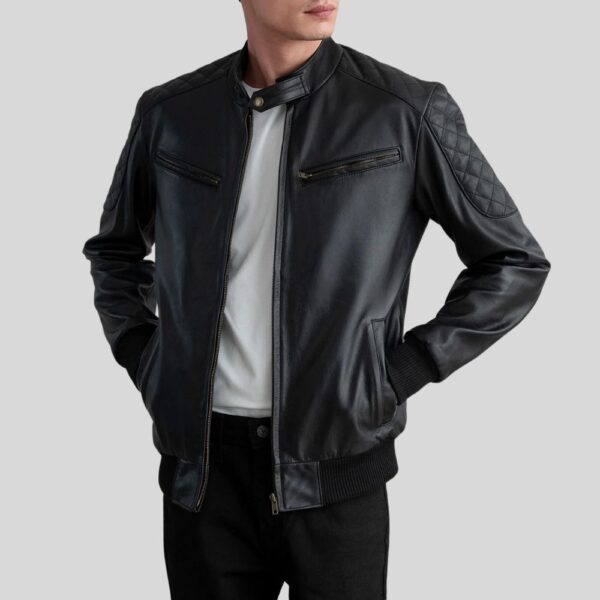 Modell trägt eine schwarze Biker Lederjacke für Herren mit gesteppten Schultern, offenem Frontreißverschluss und weißen T-Shirt darunter