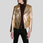 Modell trägt glänzende goldene Leder-Bikerjacke mit asymmetrischem Reißverschluss und schwarzer Hose
