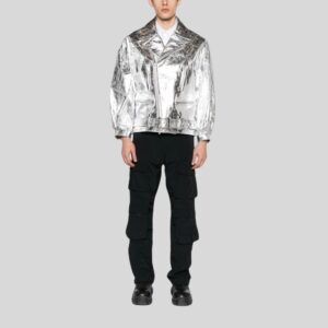 Modell trägt silberne Bikerjacke aus Metallic-Leder mit Gürtel und Reißverschluss, kombiniert mit schwarzer Cargo-Hose