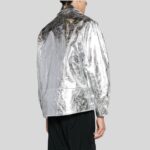 Rückansicht eines Mannes in silberner Metallic-Bikerjacke mit glatter Rückenpartie und glänzender Oberfläche