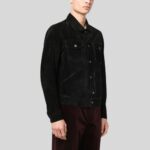 Seitlich-frontale Ansicht eines Mannes in schwarzer Wildlederjacke mit Taschen und Druckknöpfen, kombiniert mit bordeauxroter Hose