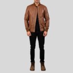 Vollansicht eines Mannes in einer braunen Leder-Bomberjacke mit Reißverschluss und Strickbündchen