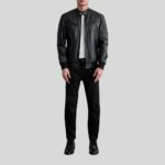 Vollansicht eines Mannes in schwarzer Biker Lederjacke mit gesteppten Schultern, weißem Shirt und schwarzer Hose