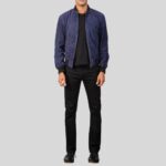 Ganzkörperansicht eines Mannes mit blauer Wildleder Bomberjacke, schwarzem Shirt und Jeans