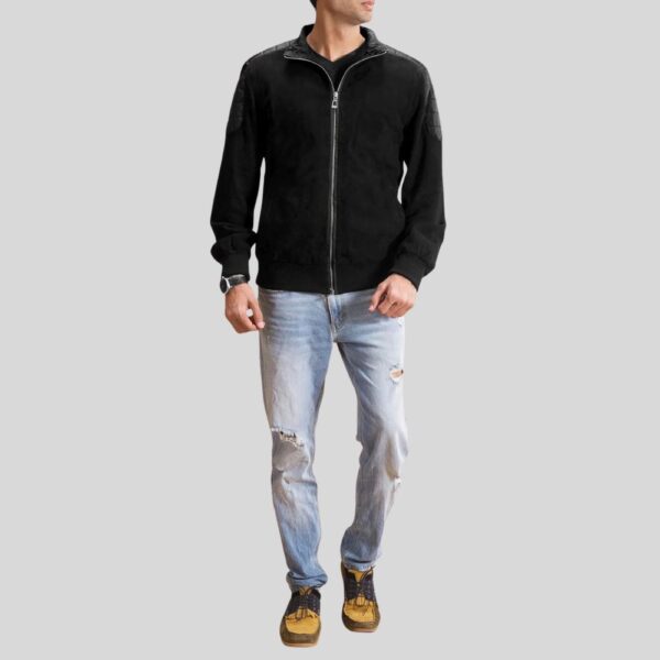 Mann trägt schwarze Wildlederjacke Herren in Kombination mit zerrissener Jeans und Sneakers