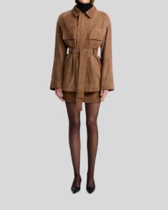 Damen Suede Mantel in Camelbraun mit Gürtel und großen Taschen, getragen über kurzem Rock und Strumpfhose