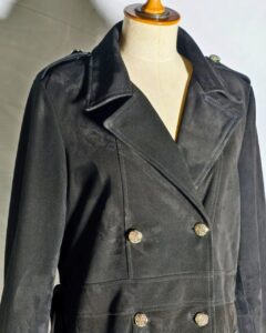 Damen Suede Trenchcoat close-up showing black suede fabric, gold double-breasted buttons, and wide lapel collar