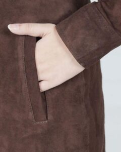 Damen brauner Wildledermantel Nahaufnahme der seitlichen Eingrifftasche mit Hand