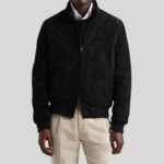 Modell trägt Herren Schwarze Suede Bomberjacke aus Wildleder mit Stehkragen und Reißverschluss, kombiniert mit heller Cordhose