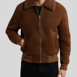 Herren trägt braune Suede Bomberjacke mit Reißverschluss, Shearling-Kragen und Rippbündchen – Hände in Seitentaschen