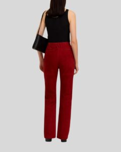 Rückansicht einer Frau in einer roten Wildlederhose mit geradem Schnitt, kombiniert mit schwarzem Top und Tasche