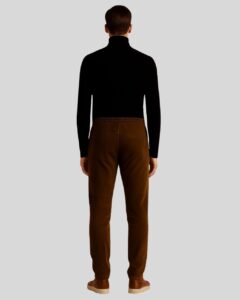 Rückansicht eines Mannes in brauner Herren Wildleder Joggerhose mit elastischem Bund, kombiniert mit schwarzem Rollkragenpullover