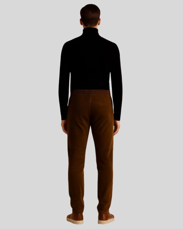 Rückansicht eines Mannes in brauner Herren Wildleder Joggerhose mit elastischem Bund, kombiniert mit schwarzem Rollkragenpullover