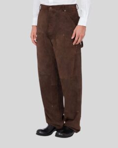 Seitenansicht eines Mannes in einer dunkelbraunen Wildleder-Utilityhose mit aufgesetzten Taschen, kombiniert mit weißem Hemd und schwarzen Stiefeln