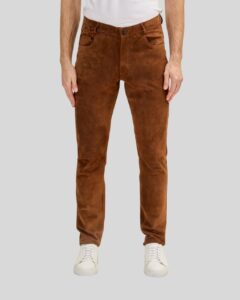 Vorderansicht eines Mannes in einer Herren Wildlederhose in Cognacfarbe, kombiniert mit weißem T-Shirt und weißen Sneakern