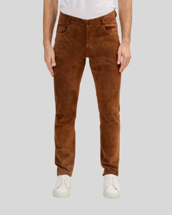 Vorderansicht eines Mannes in einer Herren Wildlederhose in Cognacfarbe, kombiniert mit weißem T-Shirt und weißen Sneakern